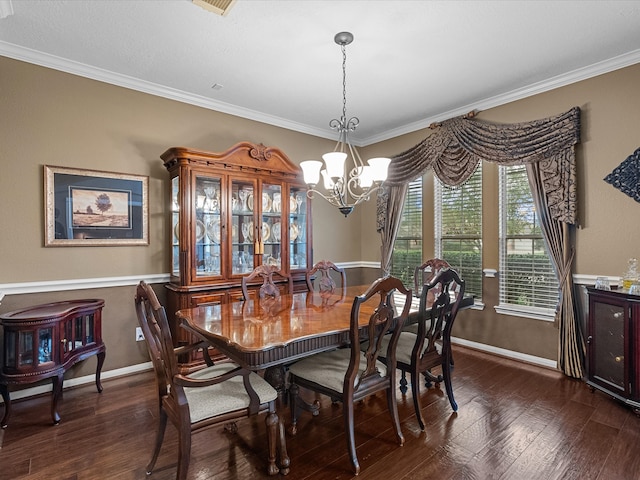 dining space featuring dark hardwood / wood-style floors, ornamental molding, and a notable chandelier