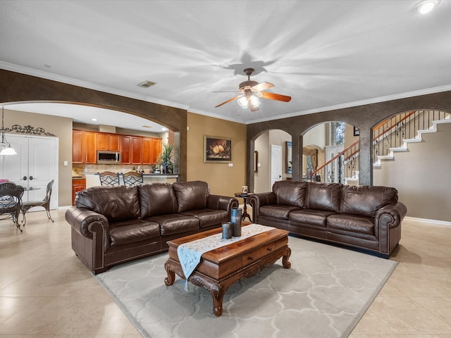 living room featuring light tile patterned floors, ceiling fan, and crown molding