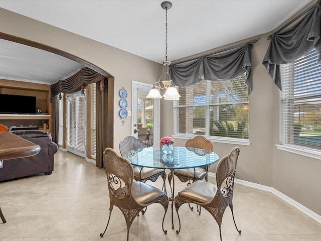 tiled dining area featuring a wealth of natural light and an inviting chandelier