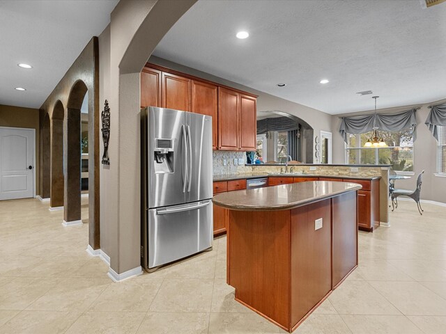 kitchen with a kitchen island, a healthy amount of sunlight, stainless steel appliances, and an inviting chandelier