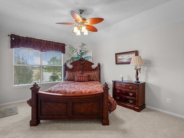 carpeted bedroom featuring a textured ceiling and ceiling fan