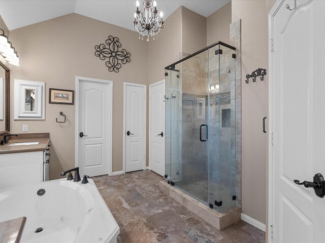 bathroom with a chandelier, vanity, vaulted ceiling, and independent shower and bath