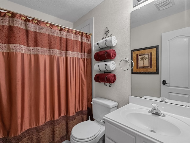 bathroom with vanity, a textured ceiling, and toilet