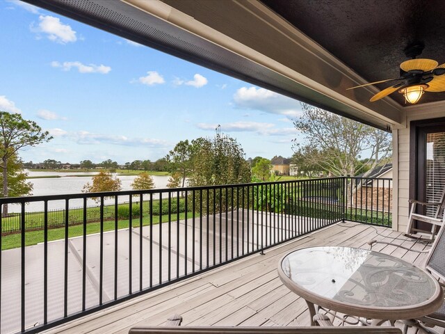 deck featuring ceiling fan and a water view