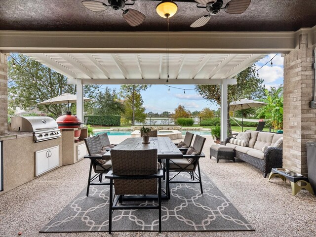 view of patio with area for grilling, ceiling fan, outdoor lounge area, and exterior kitchen