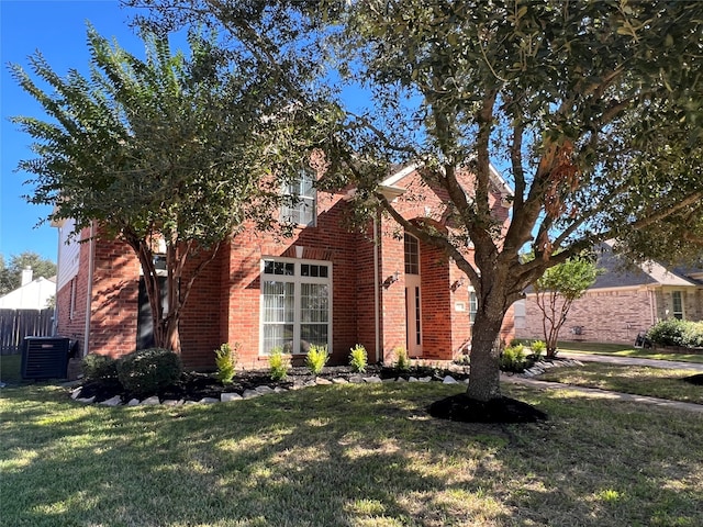 view of front of home with central air condition unit and a front yard