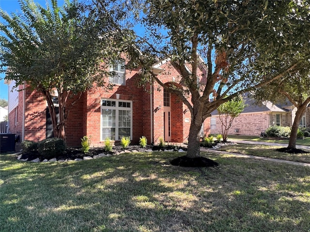 view of front of property featuring a front yard and central AC