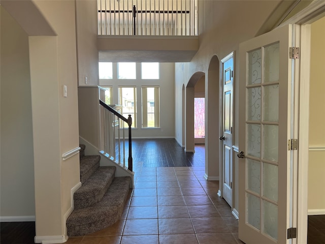 foyer with dark tile patterned floors and a high ceiling