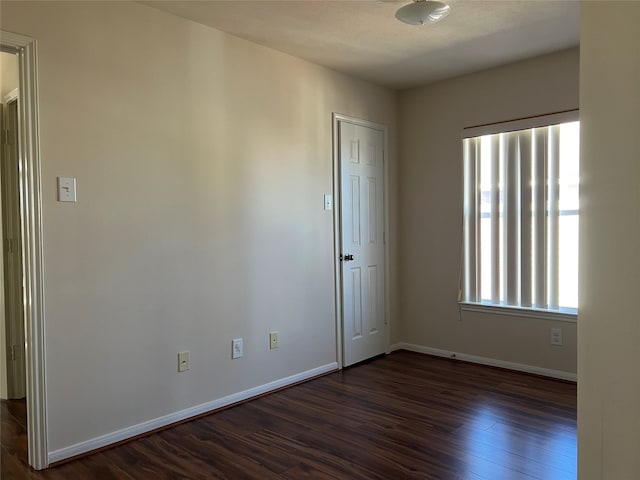 spare room with dark wood-type flooring