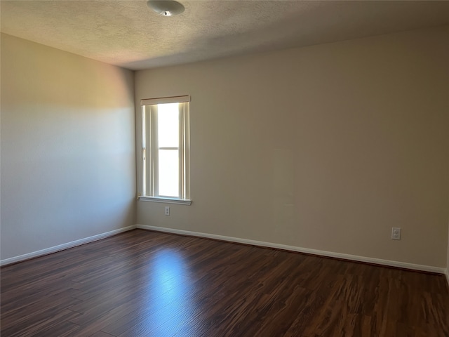 unfurnished room with dark hardwood / wood-style flooring and a textured ceiling