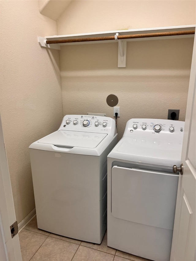 washroom with light tile patterned flooring and washing machine and dryer