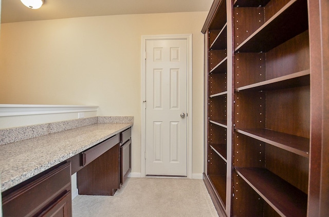 interior space featuring light carpet and built in desk