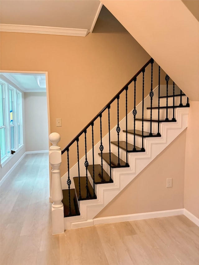 staircase featuring crown molding and hardwood / wood-style flooring