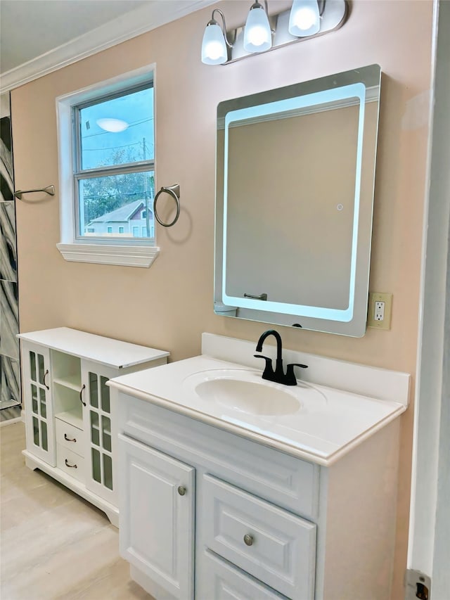 bathroom featuring crown molding, hardwood / wood-style floors, and vanity