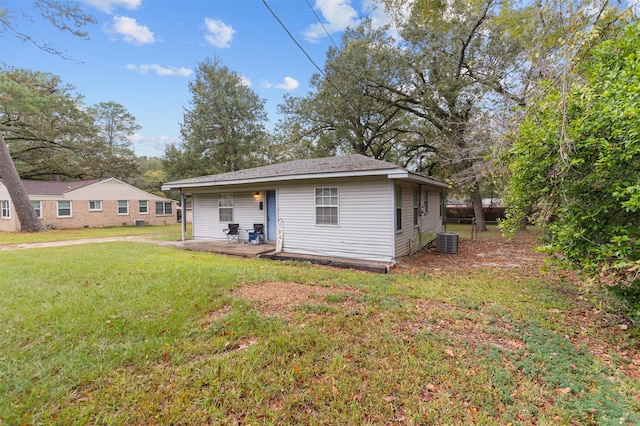 view of front of home with cooling unit and a front yard