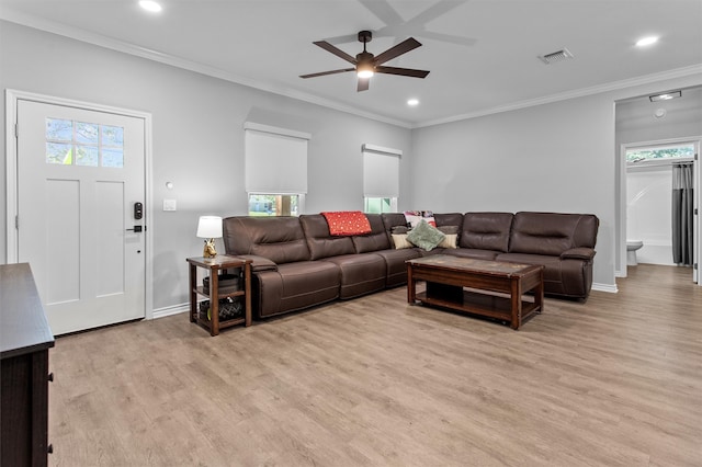 living room featuring light wood-type flooring, a wealth of natural light, crown molding, and ceiling fan