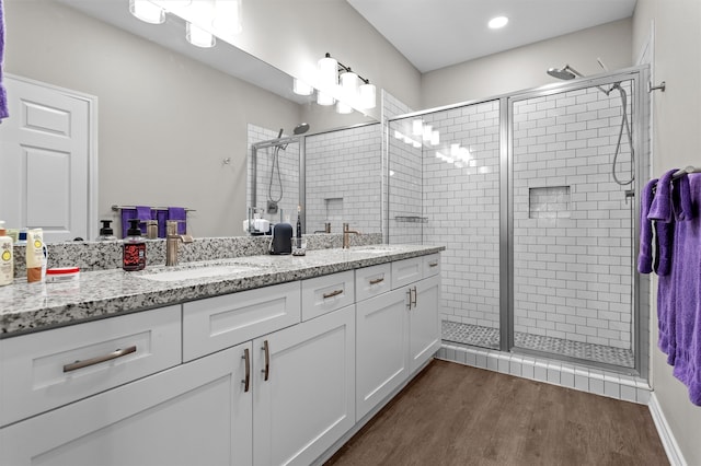 bathroom featuring hardwood / wood-style flooring, vanity, and an enclosed shower