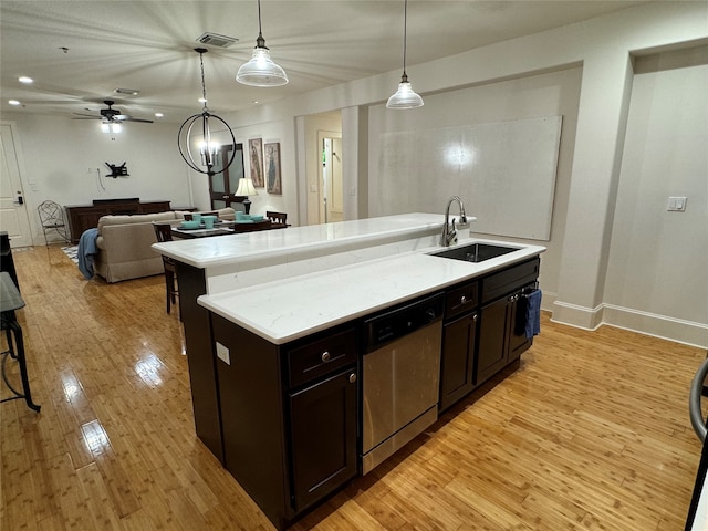 kitchen with sink, decorative light fixtures, dishwasher, light hardwood / wood-style floors, and an island with sink