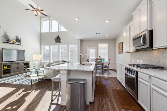 kitchen featuring white cabinetry, appliances with stainless steel finishes, sink, and a breakfast bar area