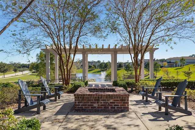 view of patio with a fire pit and a water view