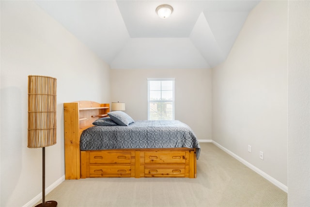 bedroom with light colored carpet and lofted ceiling