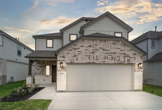 6703 Old Cypress Landing Ln, Humble, TX 77338 - view of front of property featuring stone siding, a garage, board and batten siding, concrete driveway, and roof with shingles