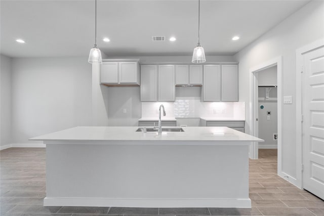 6703 Old Cypress Landing Ln, Humble, TX 77338 - kitchen with wood finish floors, visible vents, recessed lighting, a sink, and a center island with sink