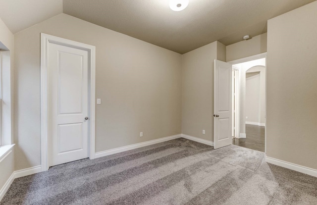 spare room with lofted ceiling and carpet floors