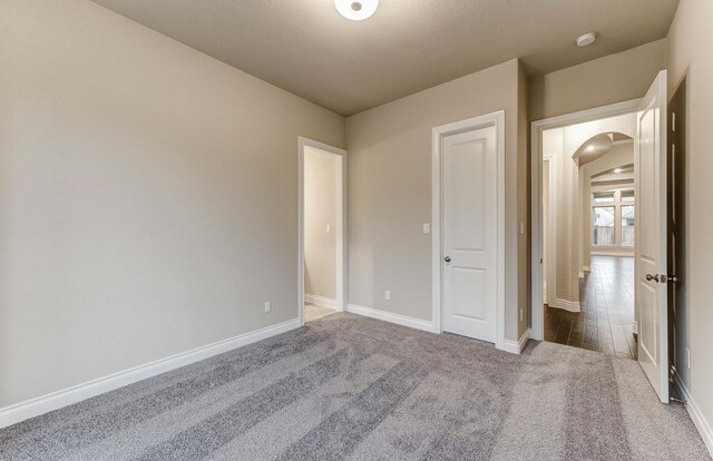 unfurnished bedroom featuring dark carpet