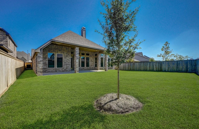 rear view of house featuring a yard and a patio