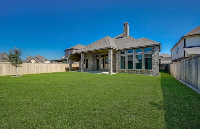 rear view of property featuring a yard and a patio