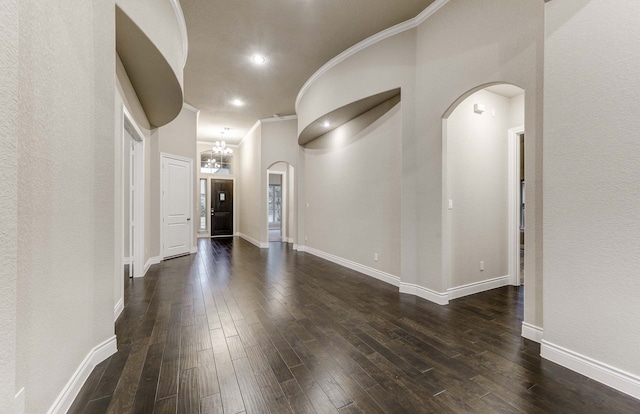 interior space with dark wood-type flooring, ornamental molding, and a chandelier