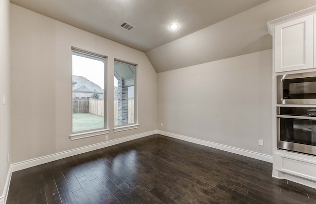 interior space with dark hardwood / wood-style flooring and lofted ceiling