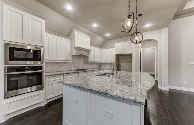 kitchen featuring an island with sink, appliances with stainless steel finishes, sink, and white cabinets