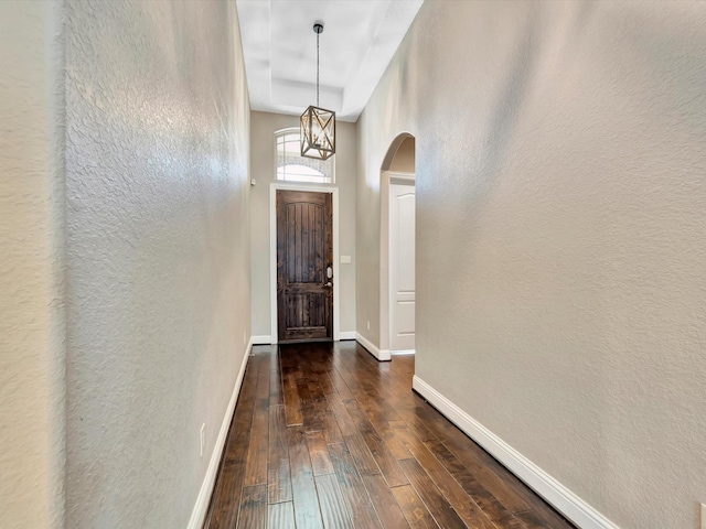 entryway with dark hardwood / wood-style floors and an inviting chandelier