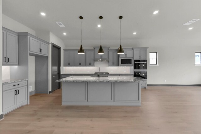 16179 Sheridan River Trl, Conroe, TX 77302 - kitchen with stainless steel appliances, gray cabinetry, light wood-type flooring, an island with sink, and recessed lighting