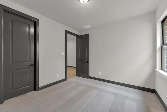 16179 Sheridan River Trl, Conroe, TX 77302 - unfurnished bedroom featuring multiple windows, baseboards, and light colored carpet