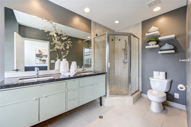 bathroom with an enclosed shower, vanity, toilet, and tile patterned floors