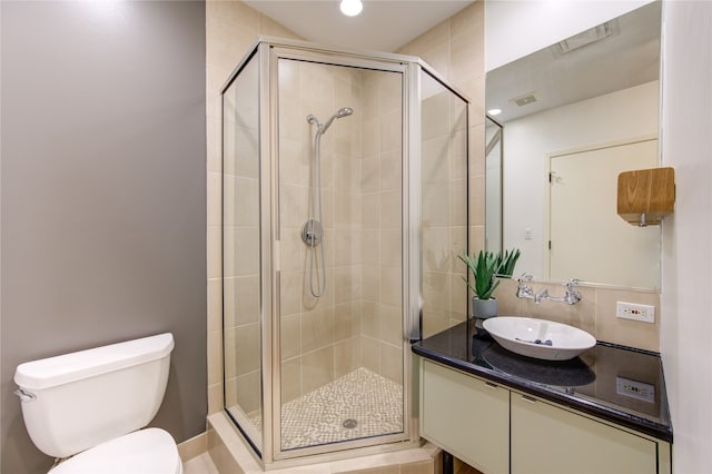 bathroom featuring tile patterned flooring, vanity, an enclosed shower, and toilet