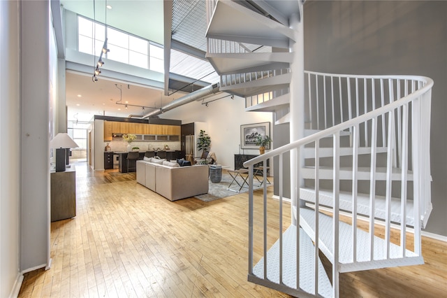 interior space with light wood-type flooring and a high ceiling