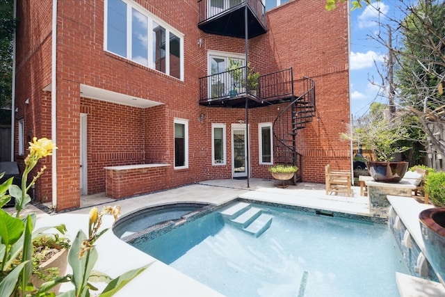 exterior space with a pool with hot tub, a patio area, and a balcony