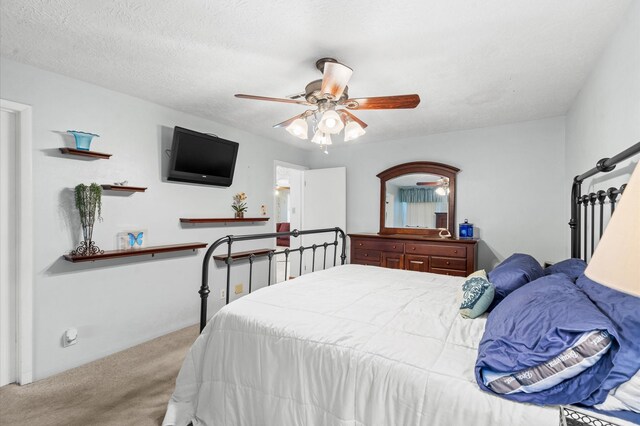 bedroom with ceiling fan, carpet, and a textured ceiling