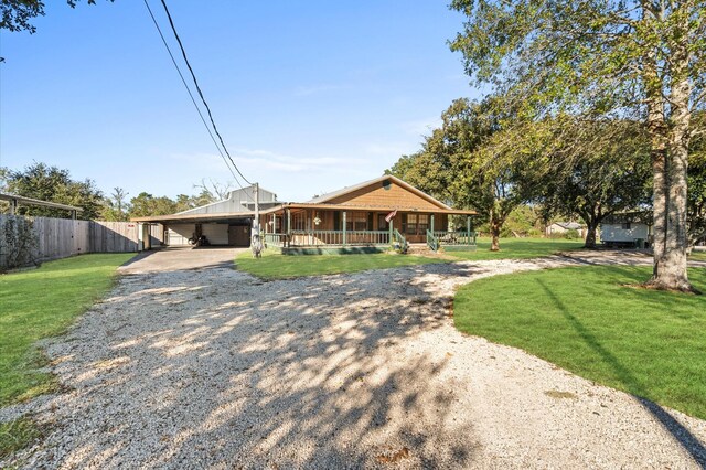 view of front of house with a carport, covered porch, and a front lawn