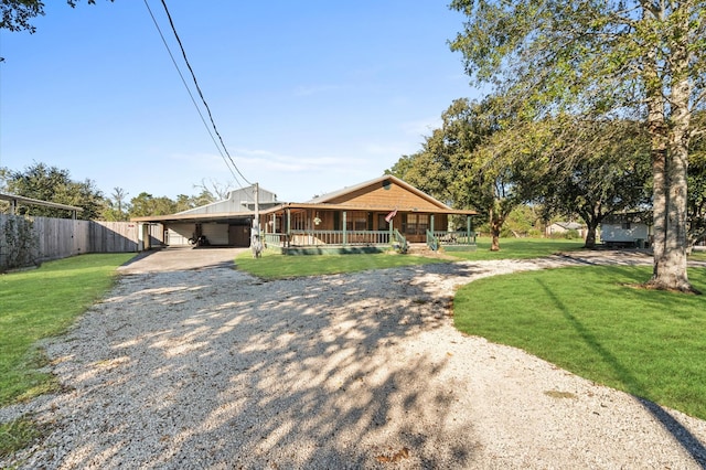 view of front of house with a front yard, a carport, and covered porch