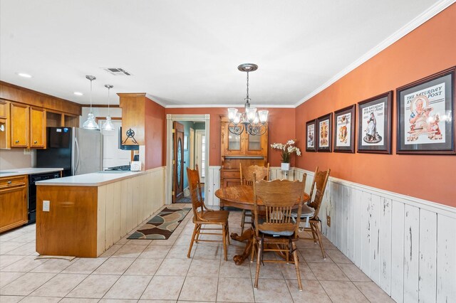 dining space featuring wood walls, ornamental molding, light tile patterned floors, and an inviting chandelier