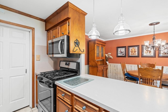 kitchen featuring ornamental molding, appliances with stainless steel finishes, decorative light fixtures, and a chandelier