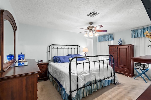 carpeted bedroom with a textured ceiling and ceiling fan