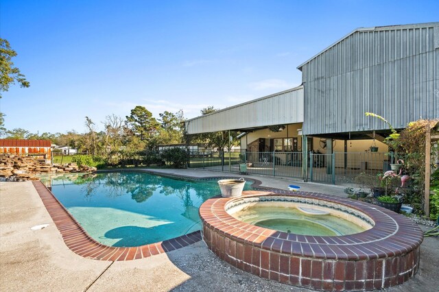 view of swimming pool featuring an in ground hot tub