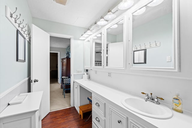 bathroom with vanity, a textured ceiling, and hardwood / wood-style flooring