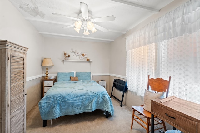 carpeted bedroom with beam ceiling, ceiling fan, and a closet